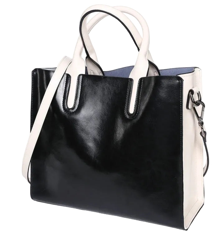 Black handbag with white handles and trim on a white background