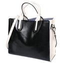 Black handbag with white handles and trim on a white background