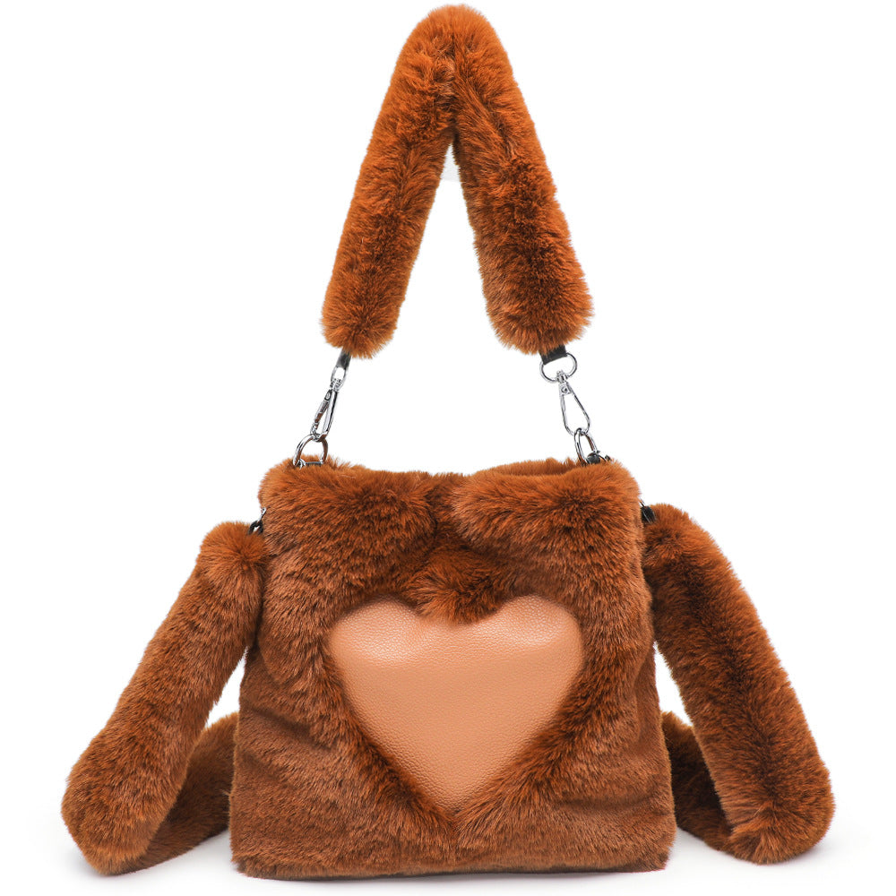 Brown fluffy handbag with heart-shaped front pocket on a white background